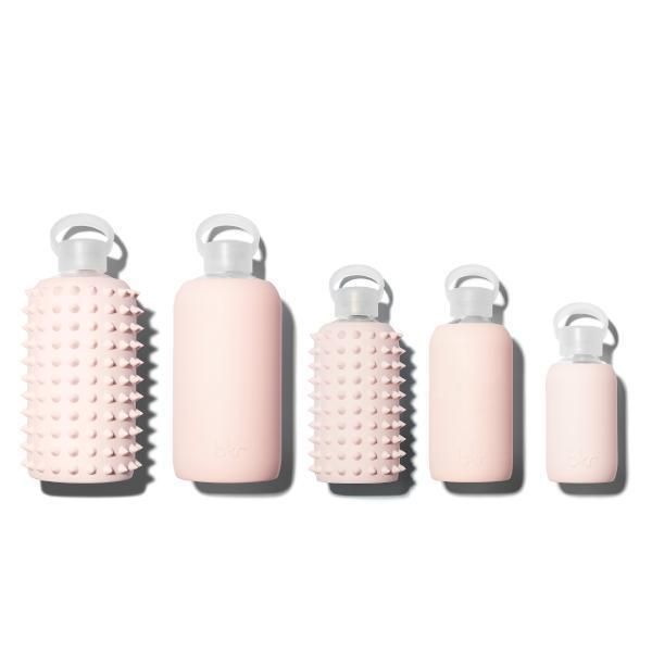 four pink bottles with handles are lined up in a row