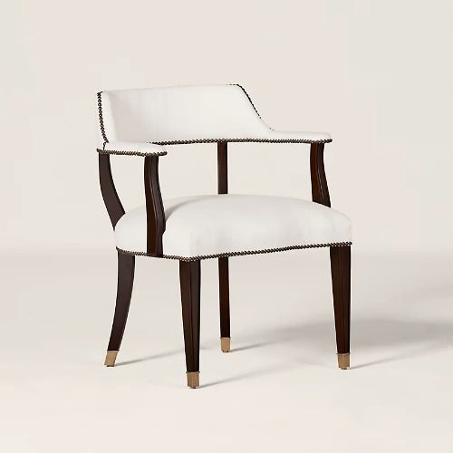 a white upholstered chair with wooden legs and nail - tipped trimmings