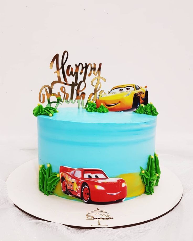 a birthday cake with cars on it sitting on a plate