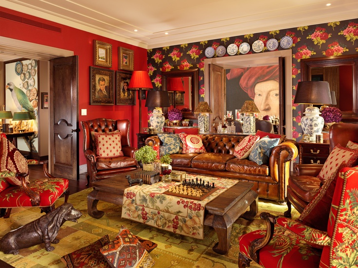 a living room filled with lots of furniture and paintings on the wall above it's windows