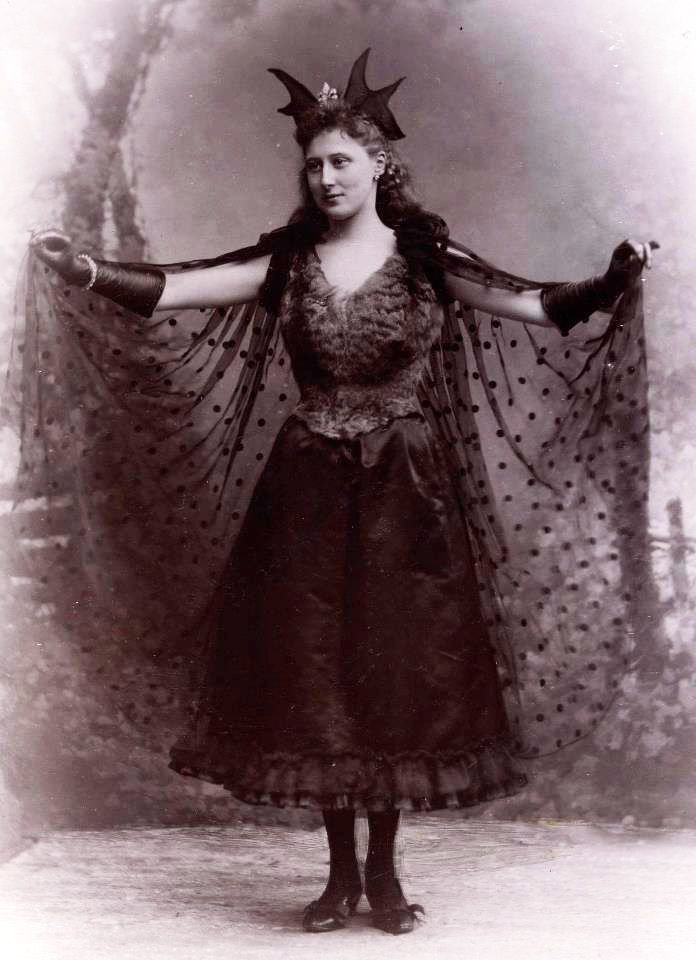 an old black and white photo of a woman wearing a costume