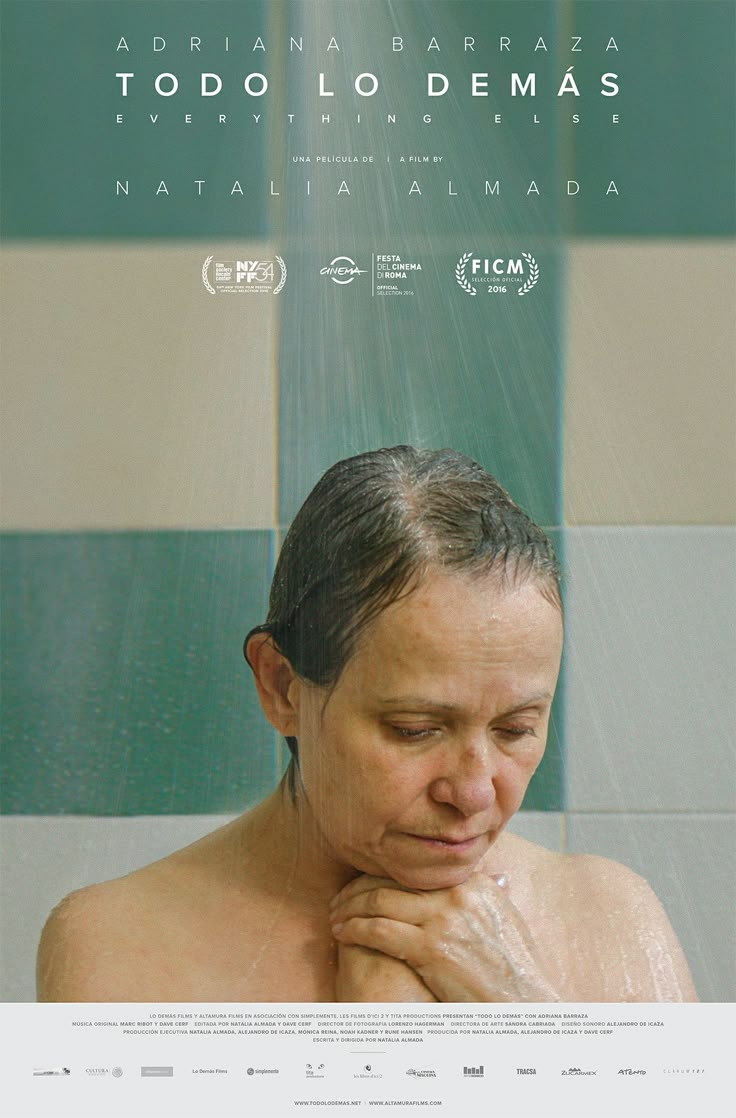 a woman in the shower with her hands under her chin and looking down at her face