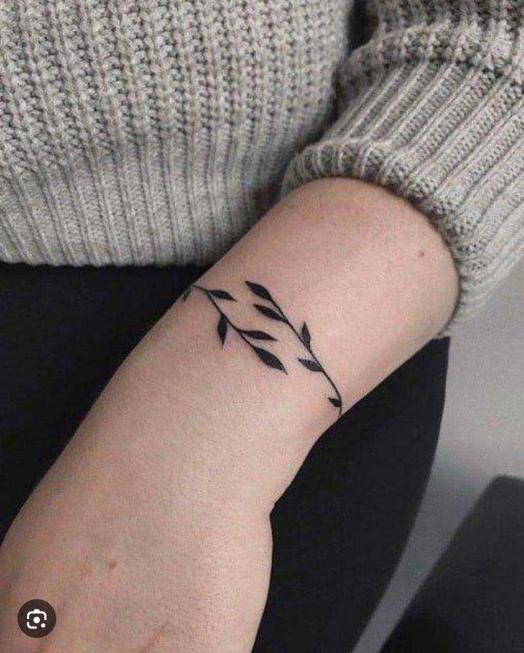 a woman's arm with an arrow tattoo on the left side of her wrist