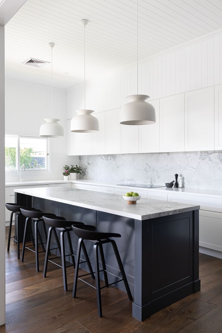 a kitchen with marble counter tops and stools in front of the island that has four black barstools