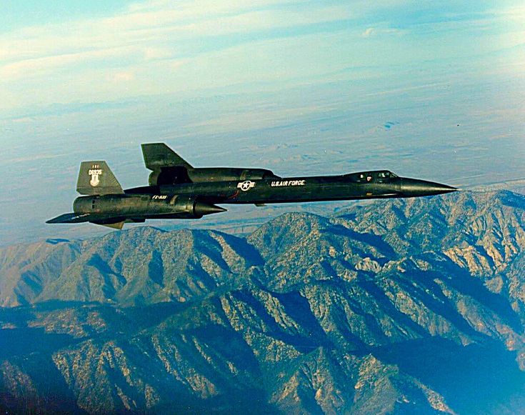 an air force jet flying over the mountains