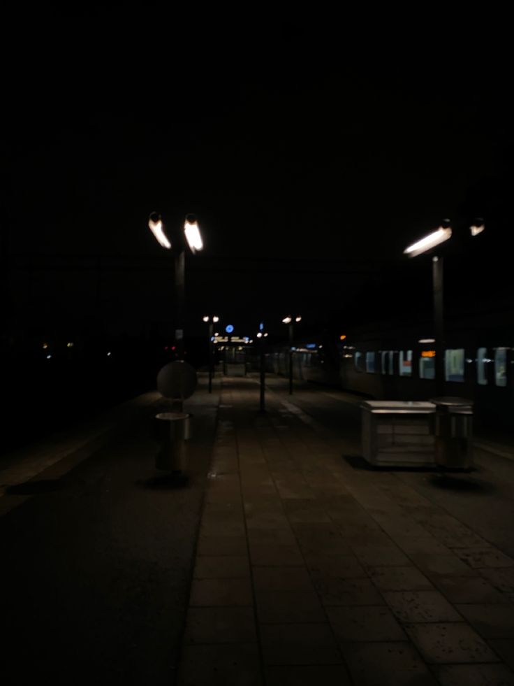 a dark street at night with some lights on