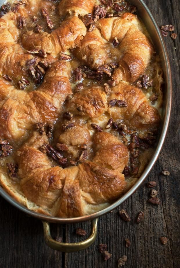 a pan filled with bread and nuts on top of a wooden table