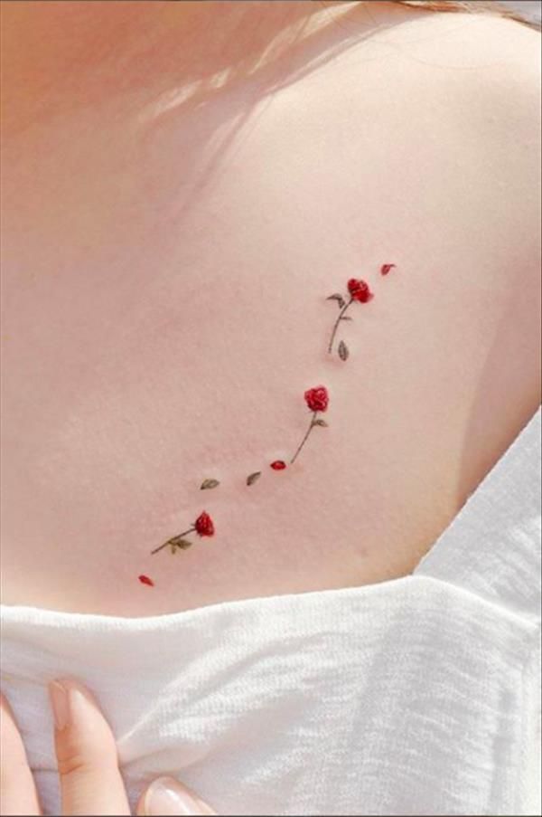 a woman's chest with red roses on it and the word love written in cursive writing