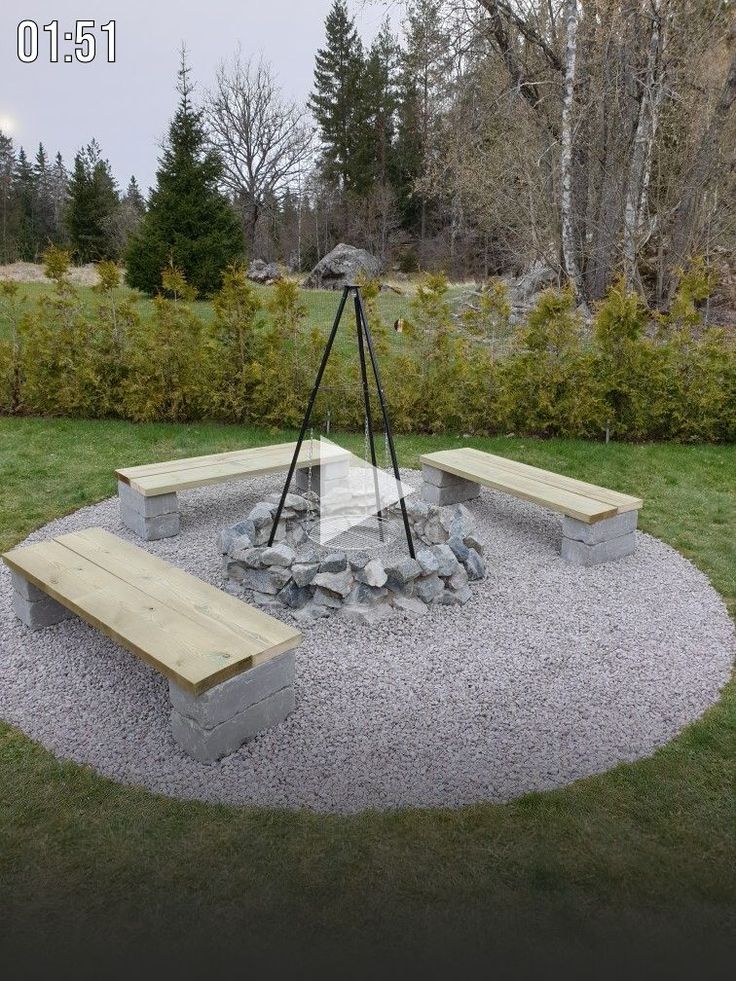 a wooden bench sitting in the middle of a gravel area with rocks and stones around it