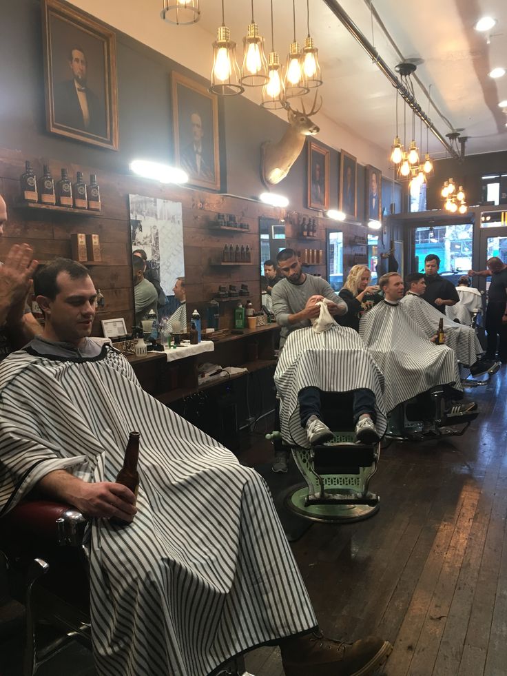 a barber shop filled with men getting their haircuts