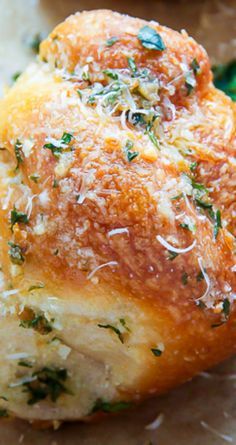 bread with cheese and herbs on it sitting on wax paper