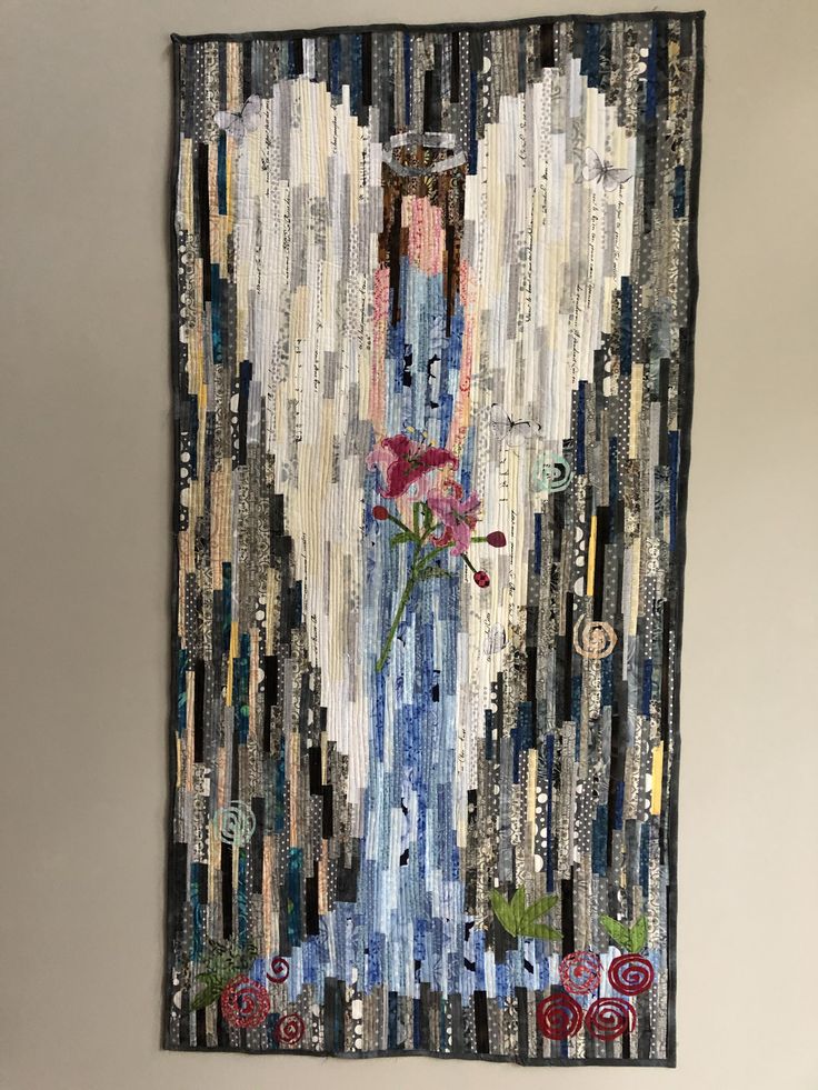 a piece of art made out of scrap paper and fabric with an angel holding a flower