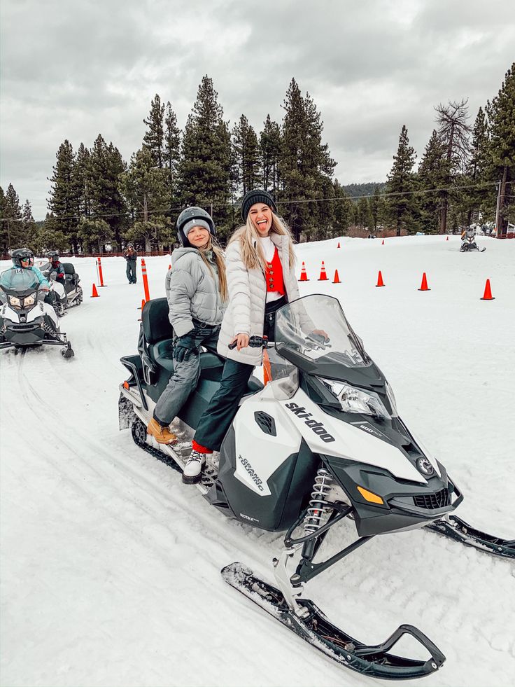 two people riding on a snowmobile in the snow