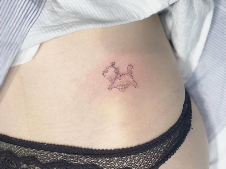 a woman's stomach with a small dog tattoo on it