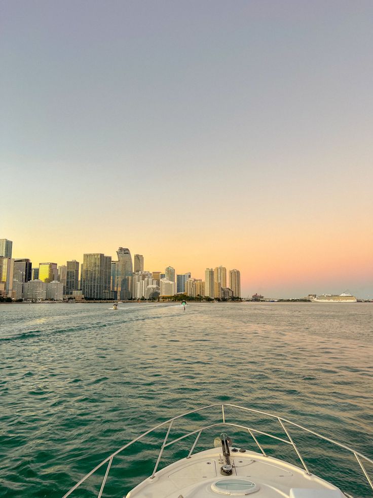 a boat traveling on the water in front of a city