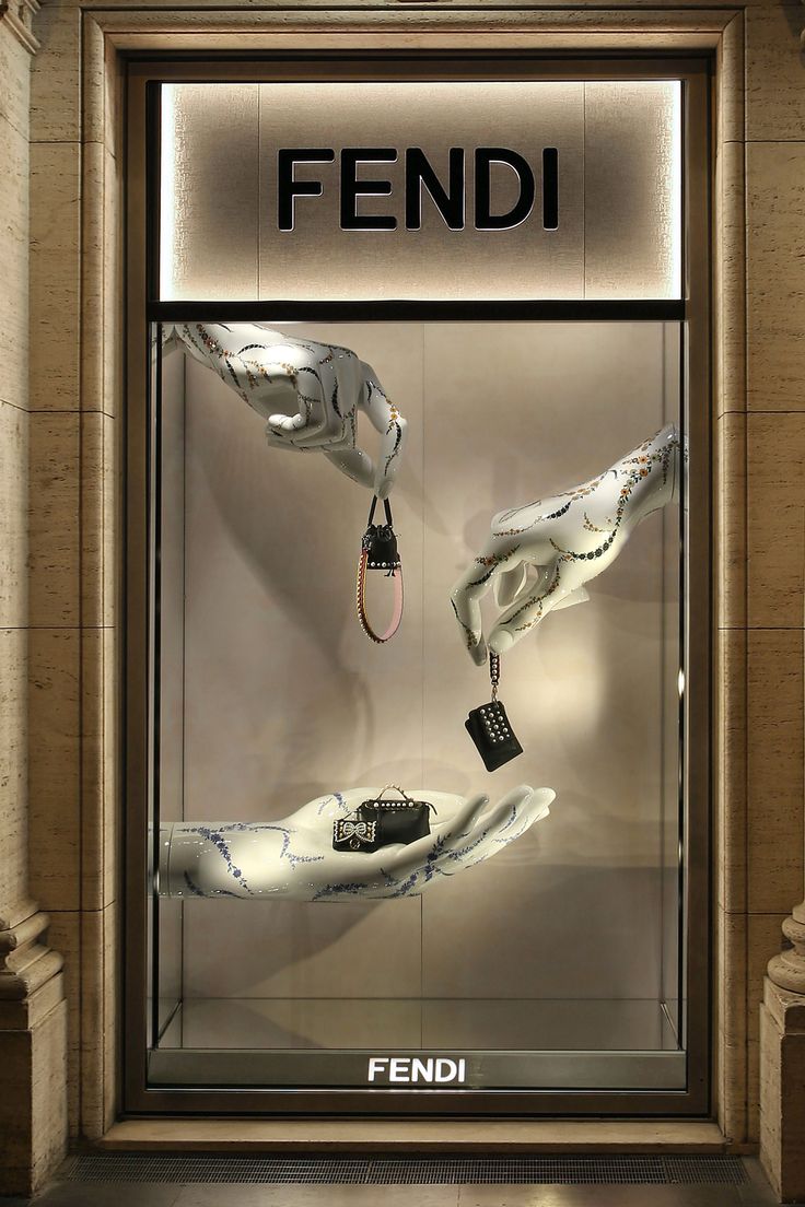 a display case with two hands holding keys in front of the glass door that says fendi