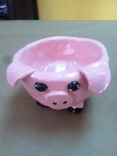 a pink pig shaped bowl sitting on top of a table