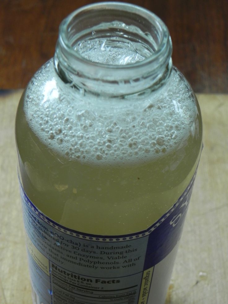 a glass bottle filled with liquid sitting on top of a wooden table