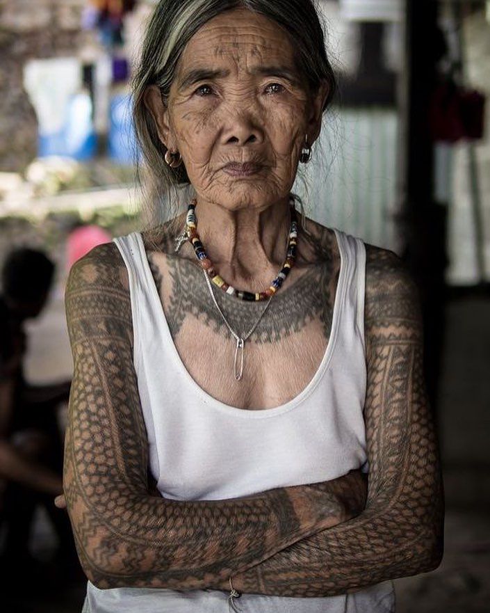 an old woman with tattoos on her arms