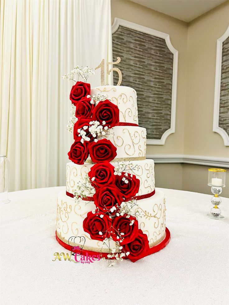 a three tiered wedding cake with red roses on top