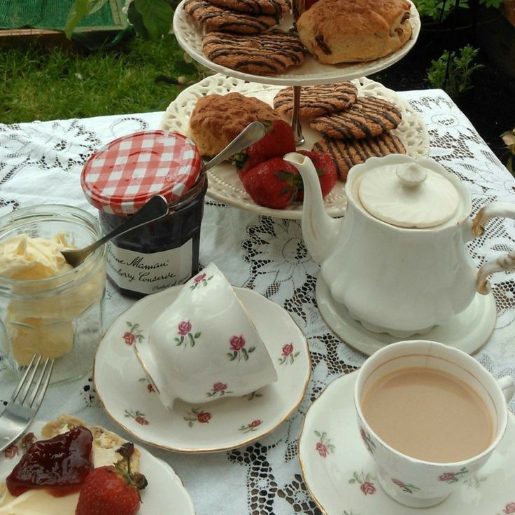 a table topped with plates of food and cups of coffee next to each other on top of a white table cloth