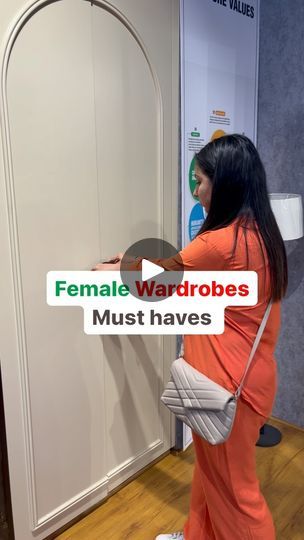 a woman standing in front of a white wall holding a mirror with the words female wardrobes must haves