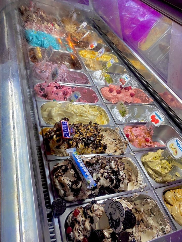 an ice cream display case filled with lots of different types of ice cream and toppings