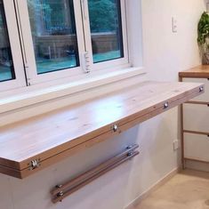 a kitchen counter with two windows in the back and one on the wall behind it