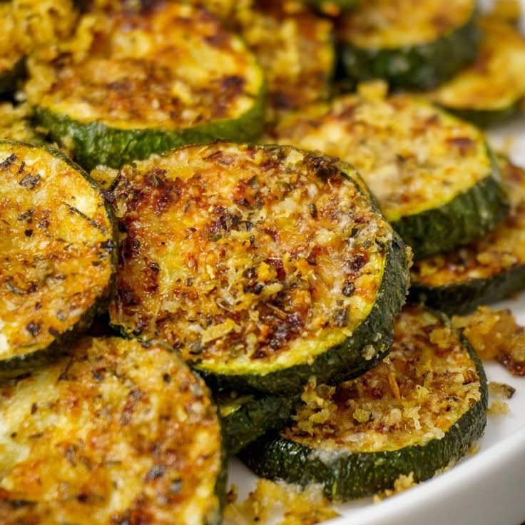 cooked zucchini on a white plate with parmesan cheese and seasoning