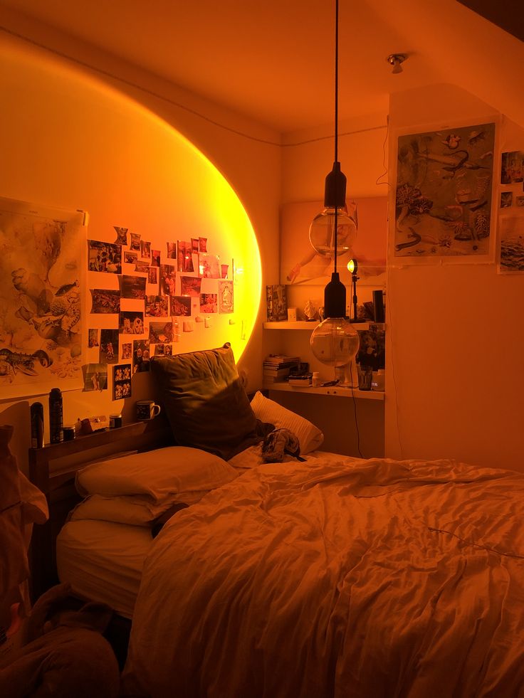 a bed room with a neatly made bed and pictures on the wall above it at night