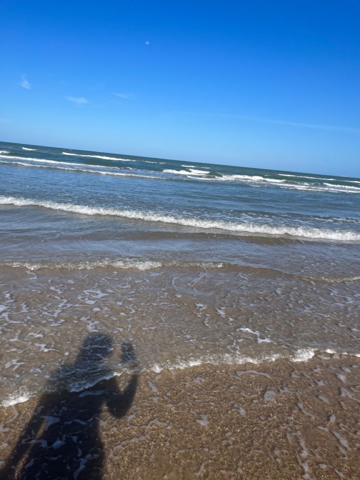 the shadow of a person standing in the water