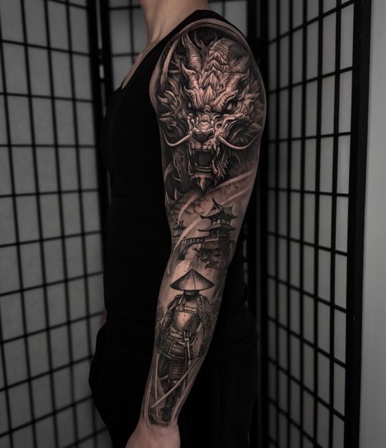 a man with a dragon and ship tattoo on his arm, standing in front of a wall