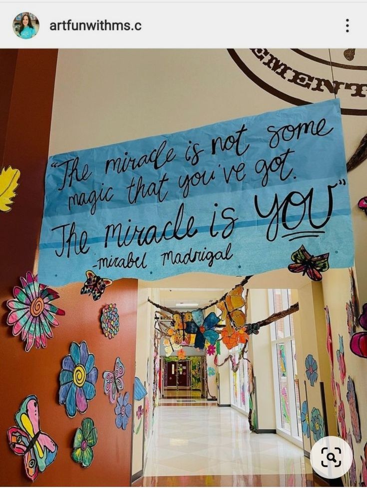 a blue sign hanging from the side of a wall next to a hallway with butterflies on it