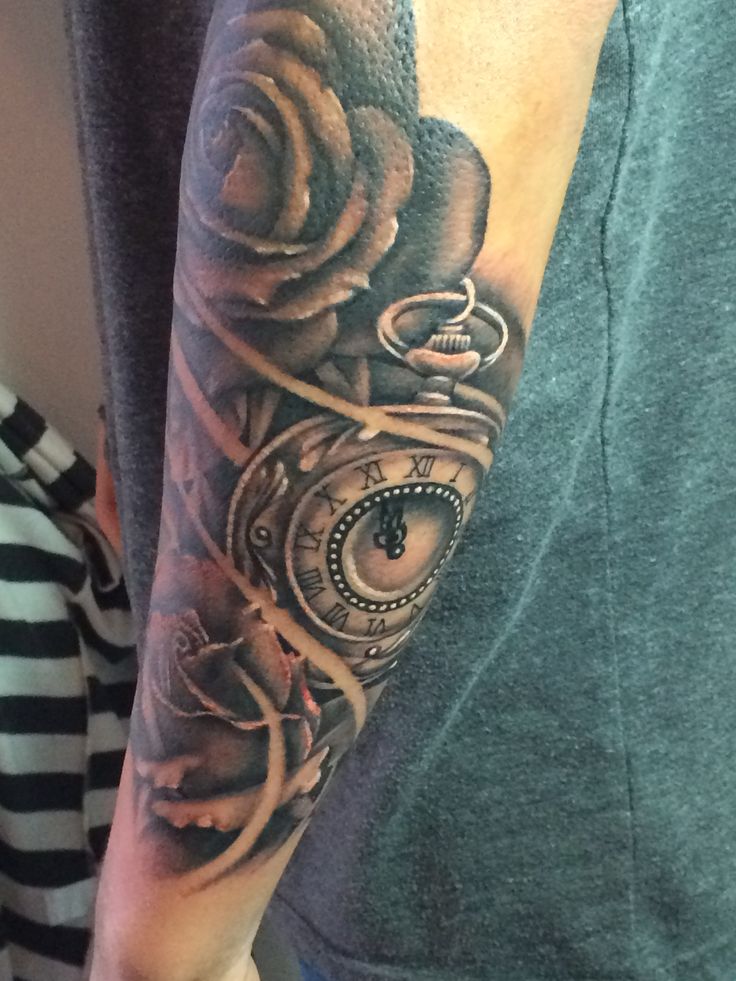 a man with a clock and rose tattoo on his arm