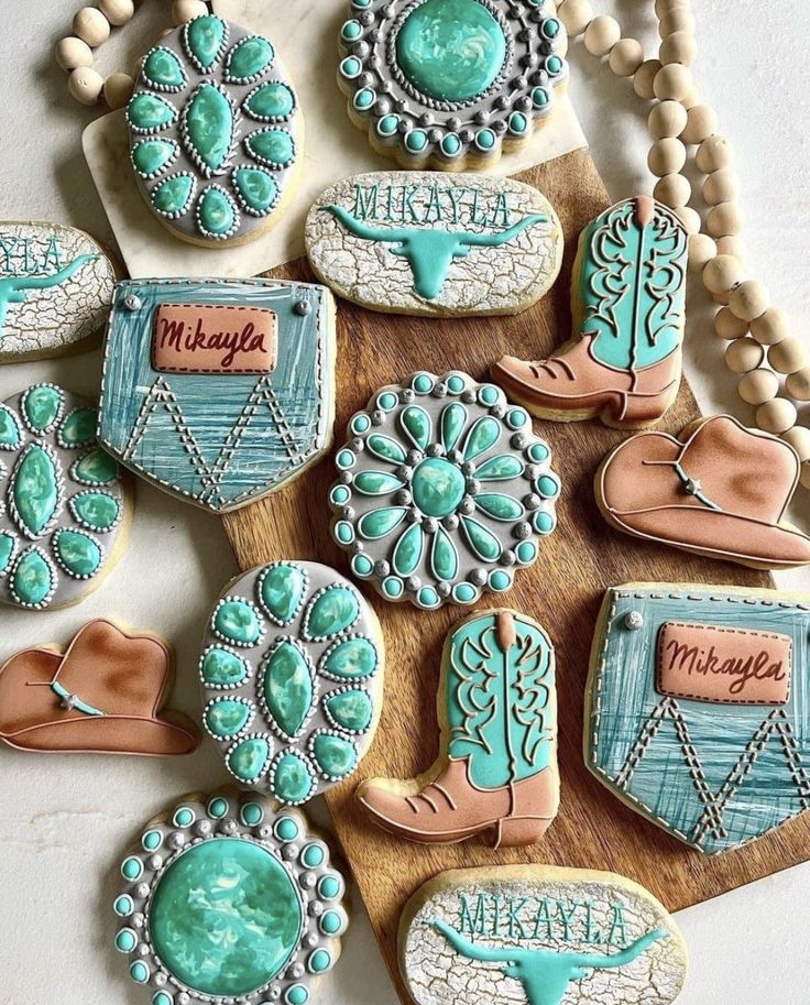 decorated cookies are arranged on a wooden board with beaded necklaces and beads around them