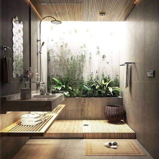 a modern bathroom with bamboo flooring and plants in the shower area, along with two sinks