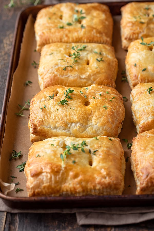 freshly baked pastries in a baking pan on a wooden table with napkins and utensils