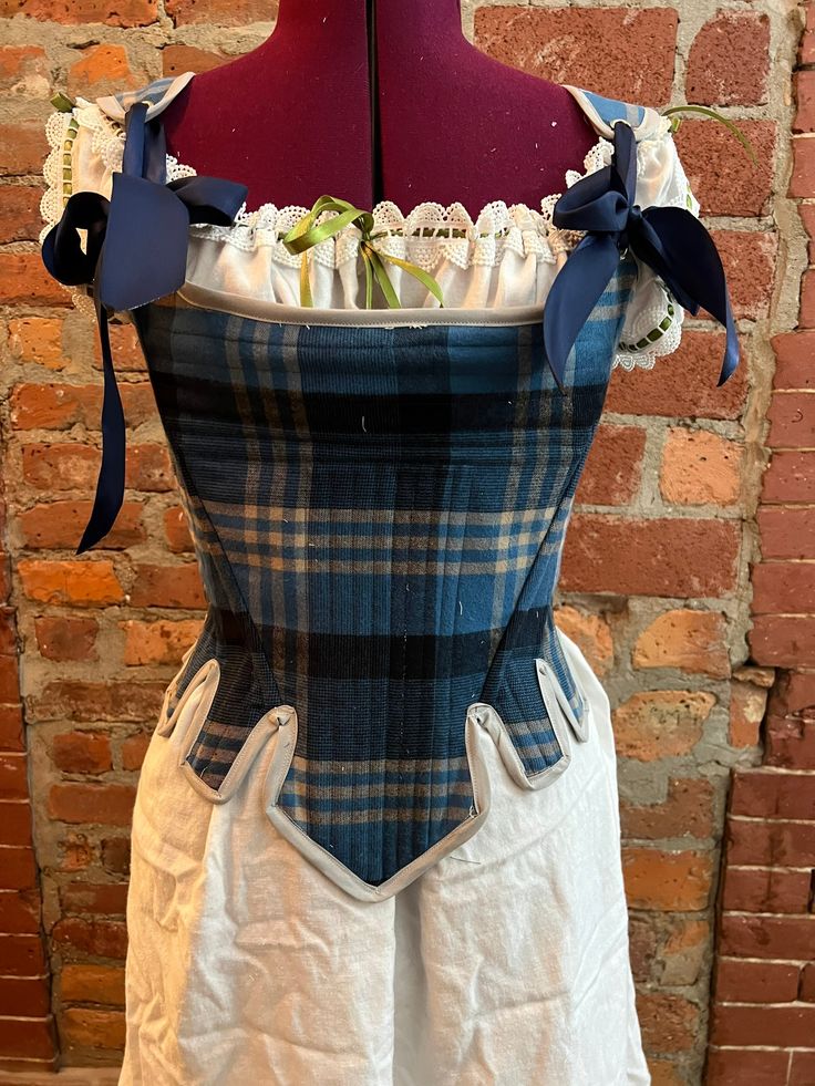 This 18th century style stays (corset) is perfect for anyone looking to add a little flare to their corset collection. They are made to order in the plaid of your choosing and can be made to measurement. Each is made with high quality steel boning and lined with cotton for comfort. The stays lace up the back, allowing the wearer to adjust how tightly they wish to wear it. fabrics may vary based on availability  ------------------CLAN TARTAN FABRICS------------  Tartan fabric from Scotland: This option you let me know what family Tartan you are looking for and I will get authentic Tartan clan fabric from Scotland. ------------SUGGESTED UNDERGARMENTS------------ -Chemise https://www.etsy.com/listing/532863789/chemise-cotton-under-gown-outlander?ref=shop_home_active_3 -Pockets https://www.ets Stays Corset, Stays Pattern, Hamilton Costume, Georgian Fashion, Plaid Corset, 18th Century Stays, 18th Century Dresses, High Fashion Dresses, Tartan Skirt