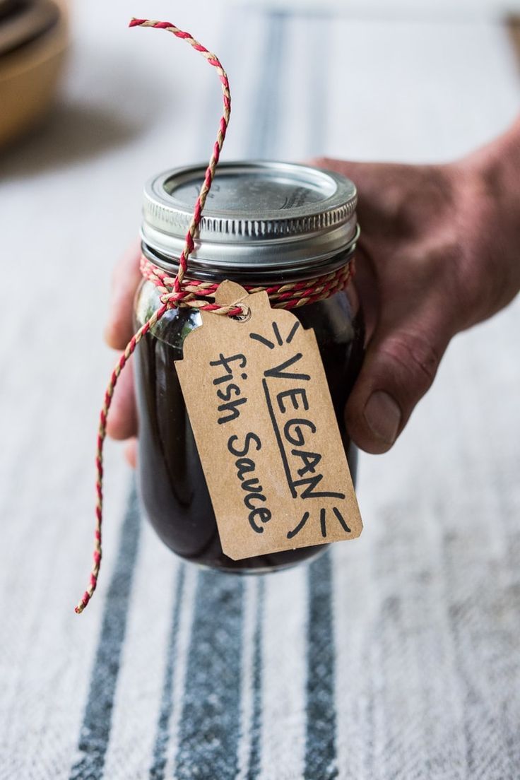 a person holding a mason jar filled with jam