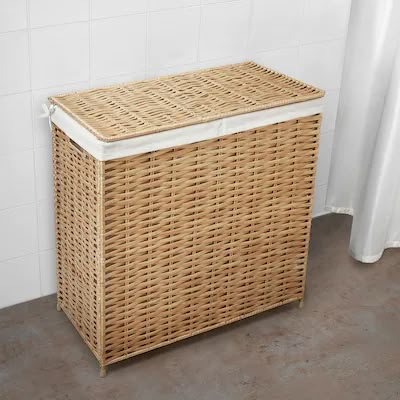 a wicker laundry basket sitting next to a white shower curtain