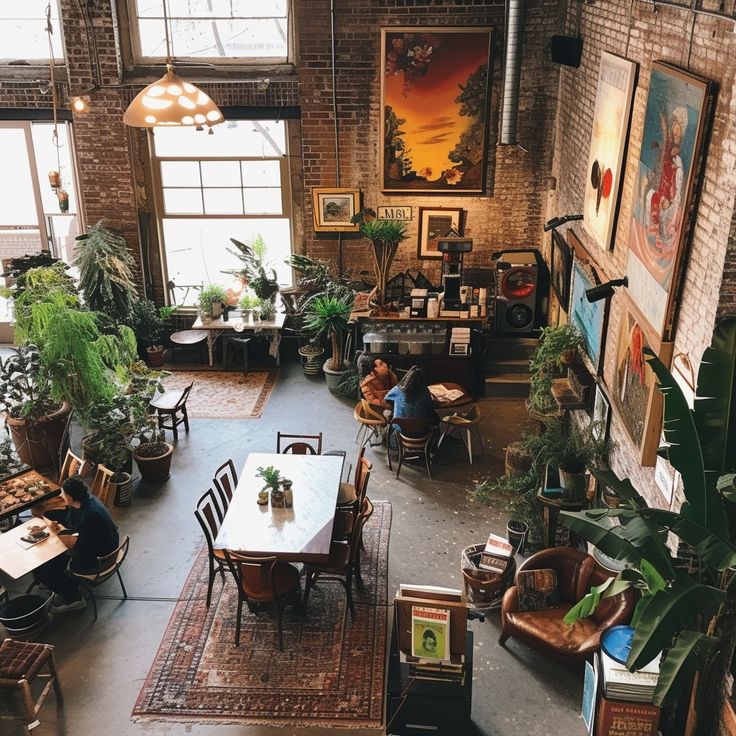 a room filled with lots of furniture and plants on the wall next to large windows