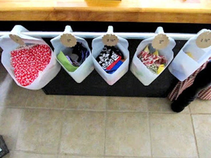 a kitchen counter with several storage bins hanging from it's sides