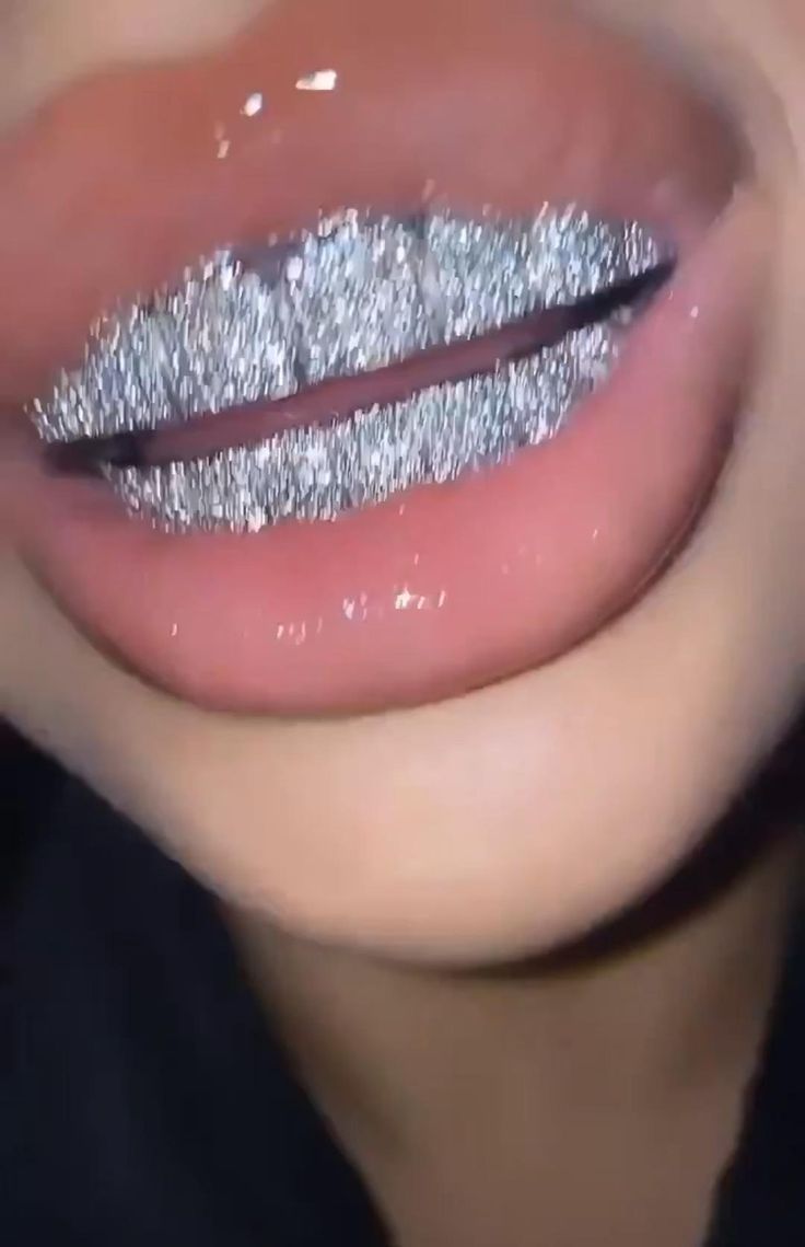 a woman's lips with silver glitter on them and her tongue sticking out to the side