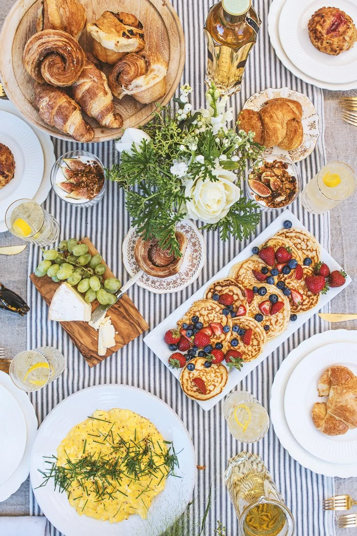 a table topped with lots of food next to wine glasses and plates filled with food