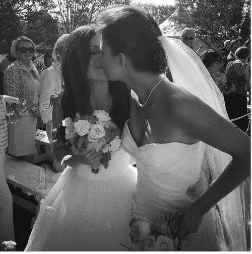 the bride and groom kiss as they walk down the aisle