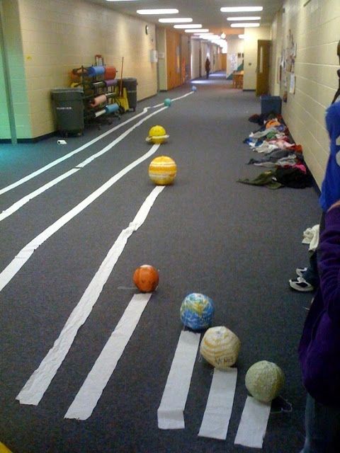 an image of some balls on the floor in a hallway with people looking at them