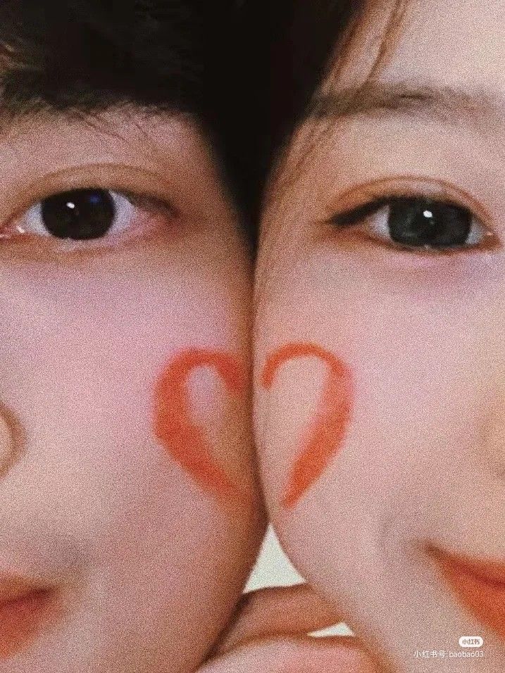 two people with faces painted like hearts