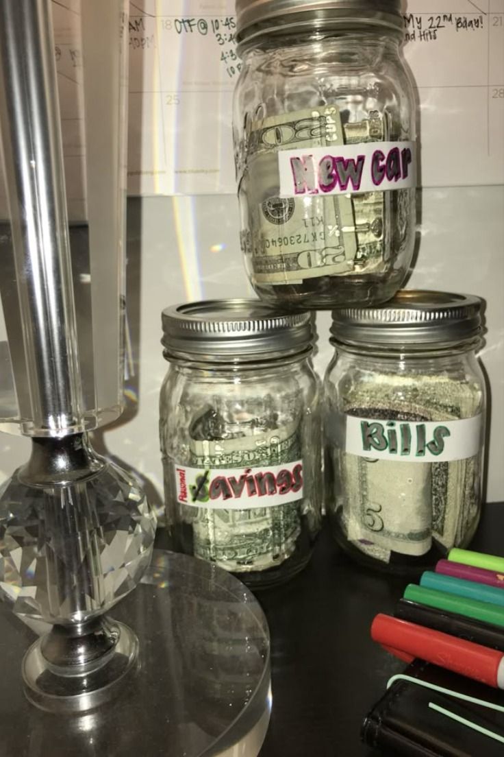 jars filled with money sitting on top of a table next to markers and pens,