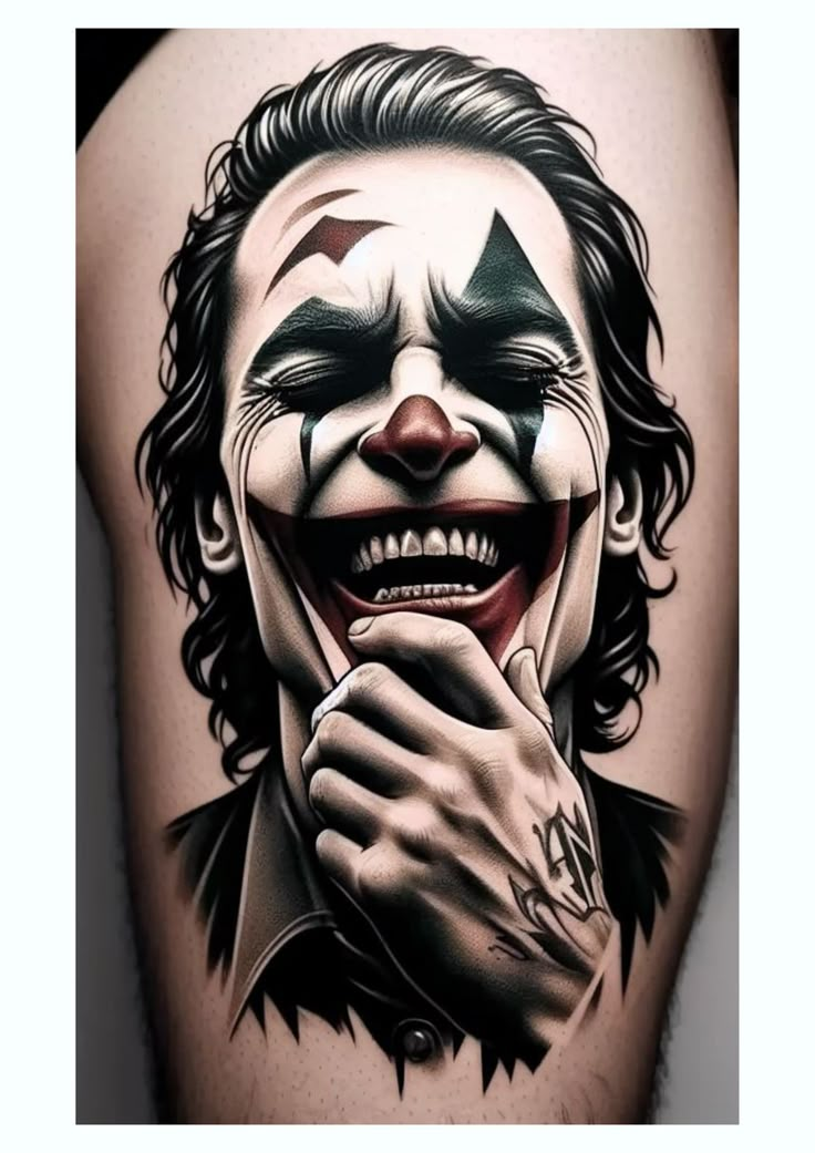 the joker tattoo is shown with his face painted in black and white, while he's holding his hand up to his mouth