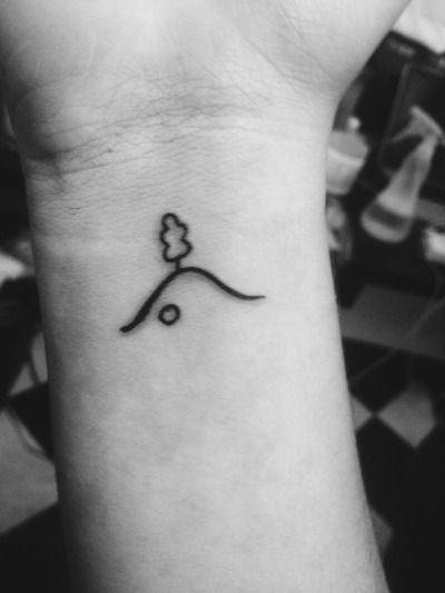 a black and white photo of a small wrist tattoo